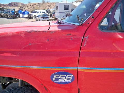 1985 Ford Bronco - This red Ford Bronco has an FSB sticker and shows signs of wear and tear on its body panels.