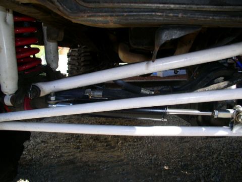 1979 Ford Bronco - Close-up view of the suspension and steering linkage underneath a vehicle.