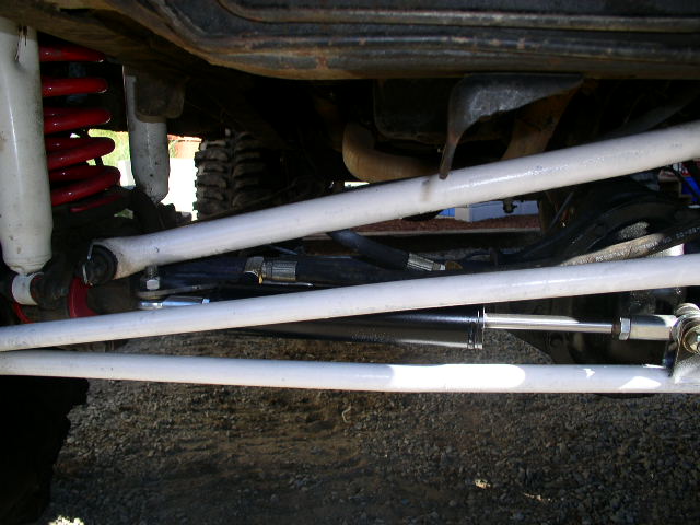 Undercarriage with white radius arms, red coil spring and steering damper