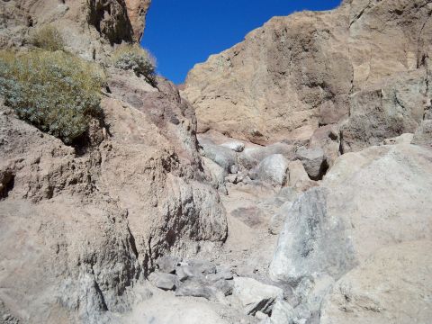 1985 Ford Bronco - A view of a rocky canyon landscape with a bright blue sky overhead.