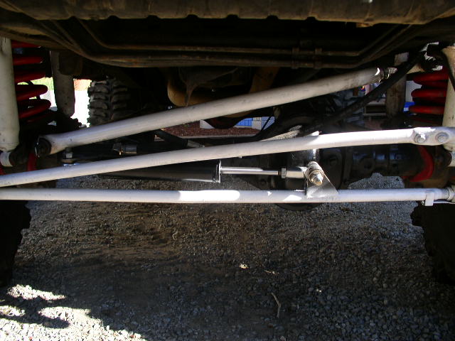 Undercarriage of a modified vehicle with white steering components and red springs