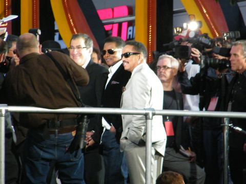 1982 Ford Bronco - A group of men, some wearing sunglasses, are seen on what appears to be a red carpet event with media present.