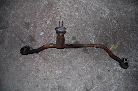1994 Ford Bronco - This is a rusted fuel line assembly with a pressure regulator, photographed on a concrete surface.