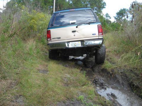1992 Ford Explorer - Ford Explorer is stuck in a muddy off-road trail, showing its rear end.