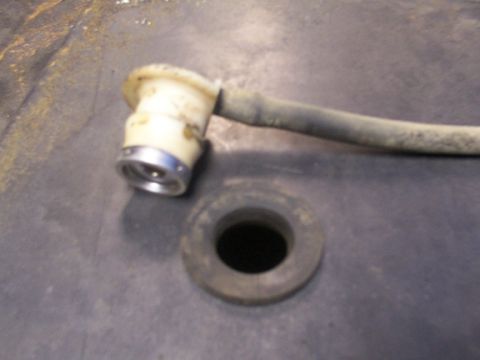 1995 Ford C-350 (Centurion Conversions) - A close-up view of a fuel tank filler neck and a rubber grommet, likely from a vehicle's fuel system.