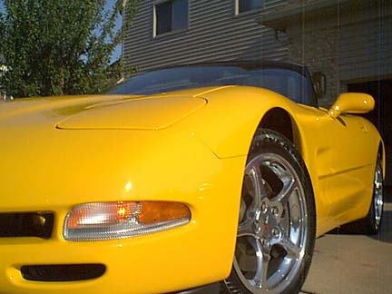 1994 Ford Mustang - A yellow convertible sports car is parked in front of a house.