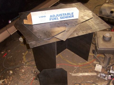 1995 Ford C-350 (Centurion Conversions) - A VDO Adjustable Fuel Sender box rests on a pile of metal sheets, with various tools and parts scattered around.