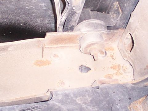 1995 Ford C-350 (Centurion Conversions) - Underside view of a vehicle's frame, showing a suspension component and signs of rust.