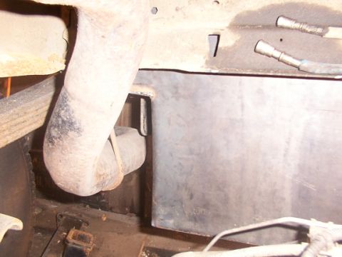 1995 Ford C-350 (Centurion Conversions) - Underside view of a custom fuel tank and exhaust pipe, likely from a truck or van.