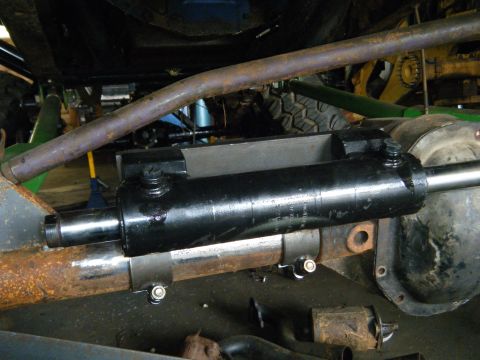 1978 Ford Bronco - Close-up of a hydraulic steering cylinder installation on an off-road vehicle's axle.