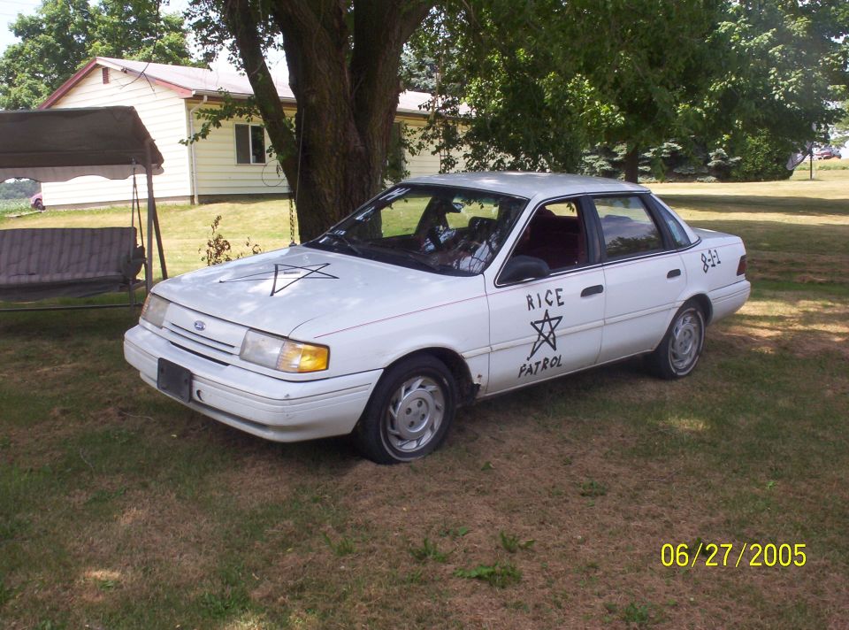 White sedan with 'RICE PATROL' text and pentagrams on hood and door. Date stamp '06/27/2005'