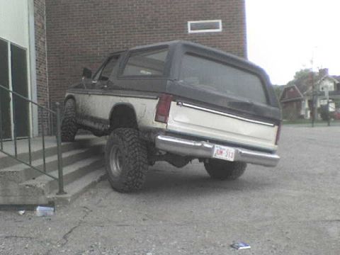 1985 Ford Bronco - Rear view of a 1985 Ford Bronco, showing its two-tone paint and lifted suspension.