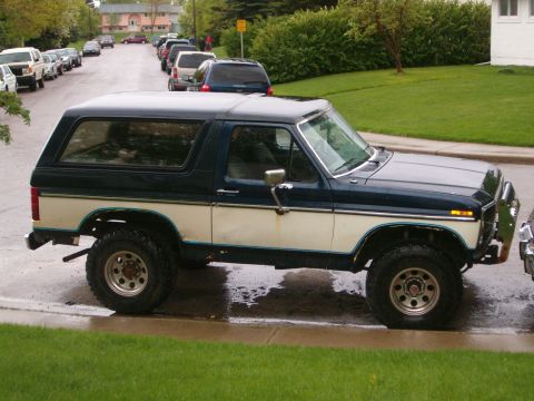 1985 Ford Bronco - Side view of a 1985 Ford Bronco with two-tone paint and off-road tires.