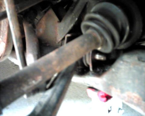 1990 Ford Taurus - Close-up view of a vehicle's CV axle and suspension components, with a SuperMotors logo visible.