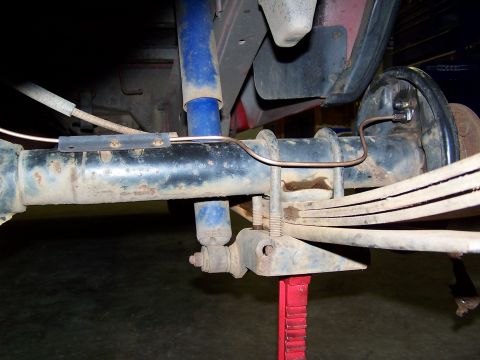 1991 Jeep Comanche - Close-up view of a vehicle's rear axle and suspension system, showing leaf springs and brake lines.