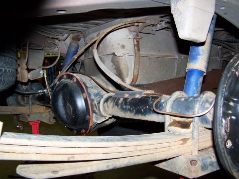 1991 Jeep Comanche - The underside of a vehicle shows the rear axle, leaf springs, and suspension components.