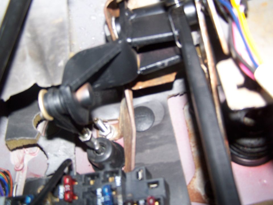 Interior view of a vehicle's pedal assembly with wiring and fuse box