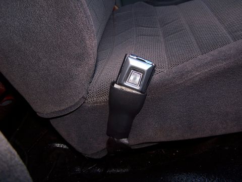 1991 Jeep Comanche - Close-up of a seatbelt buckle against a dark fabric seat interior.
