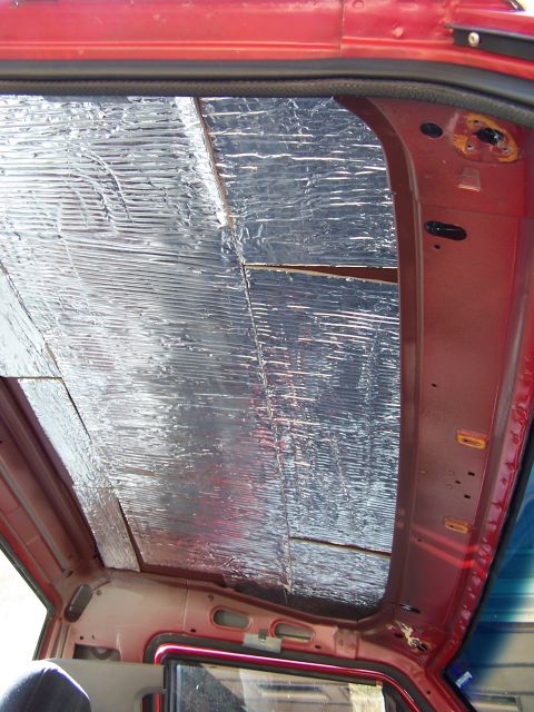1991 Jeep Comanche - Soundproofing material is applied to the interior ceiling of a red vehicle.