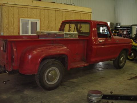 1991 Ford Bronco - A red pickup truck is parked inside a garage, with a toolbox visible in the bed.