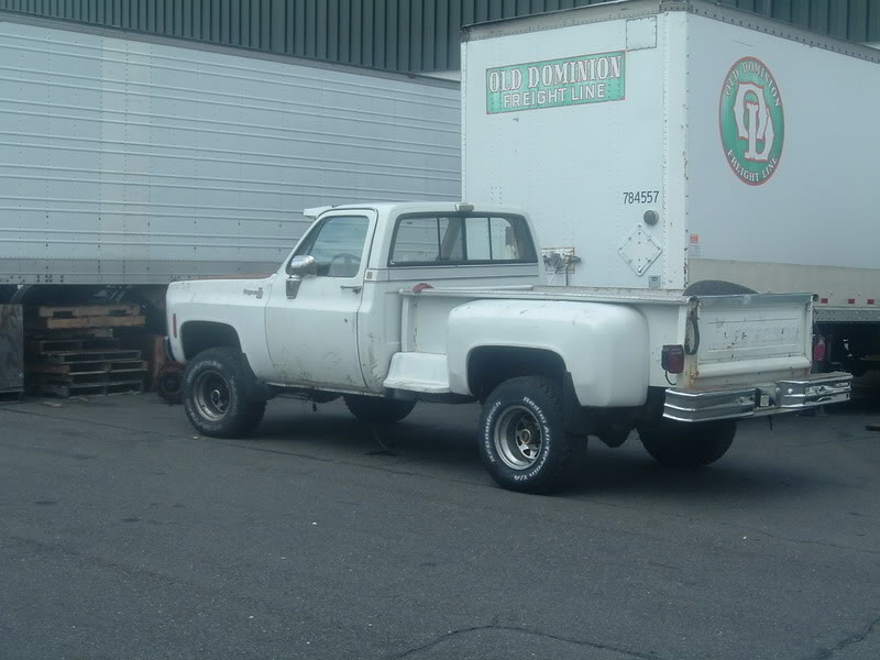 White pickup truck parked next to a semi-trailer