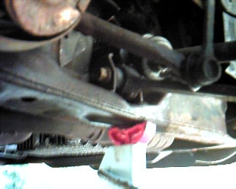 1990 Ford Taurus - The underside of a vehicle is shown, with suspension components and a red object visible.