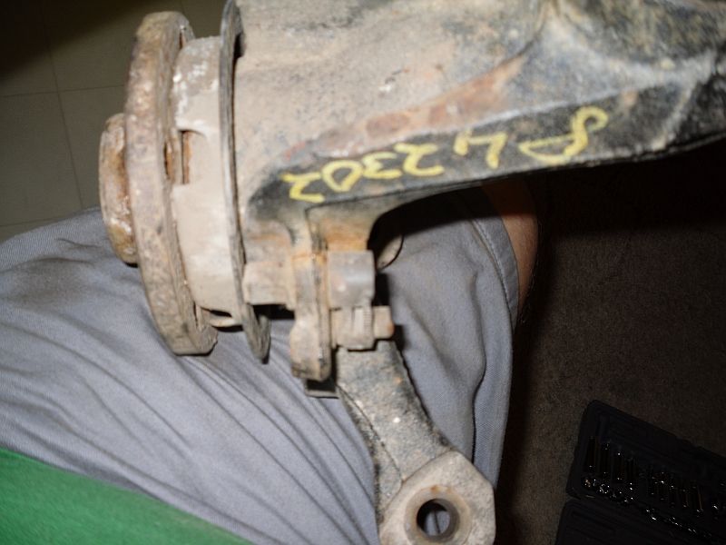 Close-up of a rusty automotive part with yellow markings 'S L 2302'