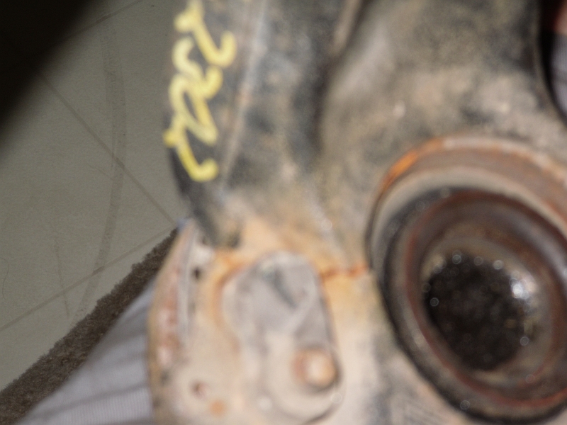 Close-up of a rusty vehicle part with yellow markings