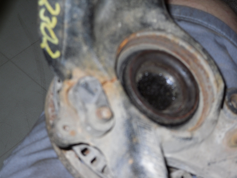 Close-up of a rusty metal automotive suspension component with yellow markings