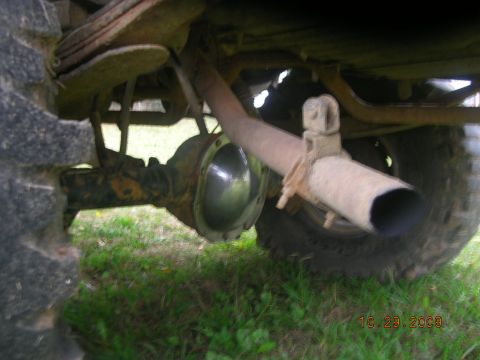 1991 Ford F-150 - Close-up of the rear axle and exhaust system of a vehicle, showing rust and wear.