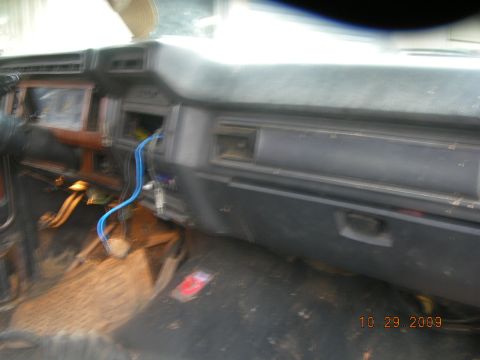 1991 Ford F-150 - The dashboard and floor of a vehicle are visible, with some wiring exposed and a timestamp in the corner.