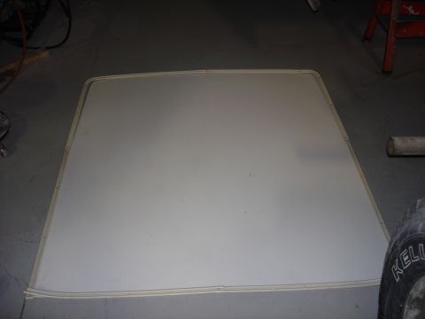 1979 Ford F-250 - A detached vehicle headliner is shown lying flat on a garage floor.