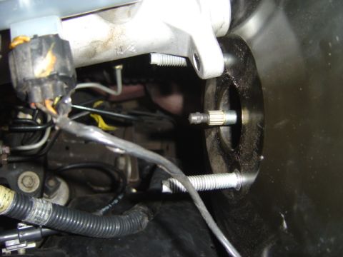 2007 Ford Mustang - Close-up view of a brake master cylinder pushrod assembly, showing associated wiring and connectors.