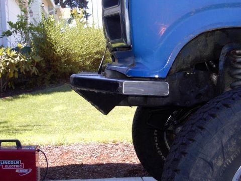 1980 Ford Bronco - A blue truck's front bumper and tire are shown, with a Lincoln Electric welder nearby.