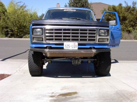 1980 Ford Bronco - This blue Ford Bronco features a custom bumper and large tires, viewed from the front.