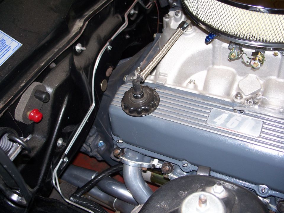 Close-up of a V8 engine with "46" visible on the valve cover. Air filter housing and oil cap are also in view
