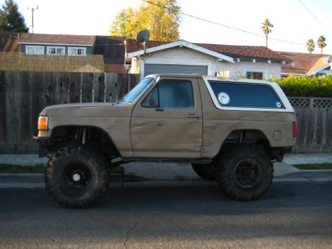 1989 Ford Bronco - This modified Ford Bronco features a lifted suspension and oversized tires, giving it a appearance.