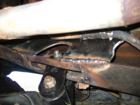 1989 Ford Bronco - Close-up view of a heavily modified vehicle frame, showing extensive welding and bolted components.