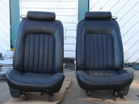 1973 Ford Ranchero - Two black leather car seats with headrests are displayed side-by-side on a cardboard mat.
