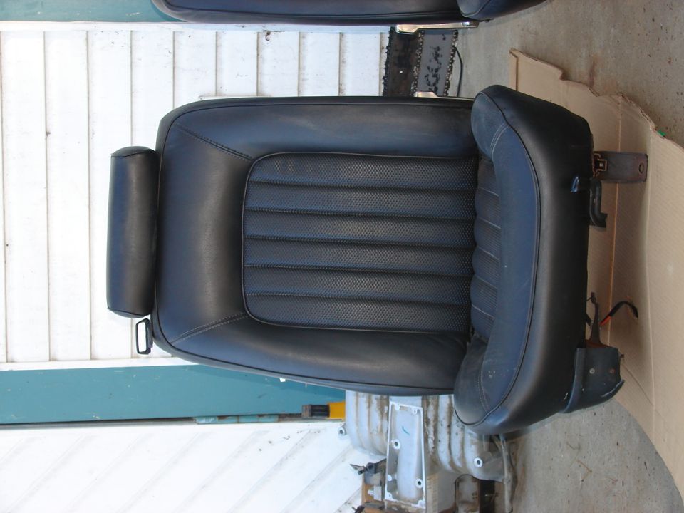 Black leather car seat with horizontal stitching on the backrest and a padded headrest