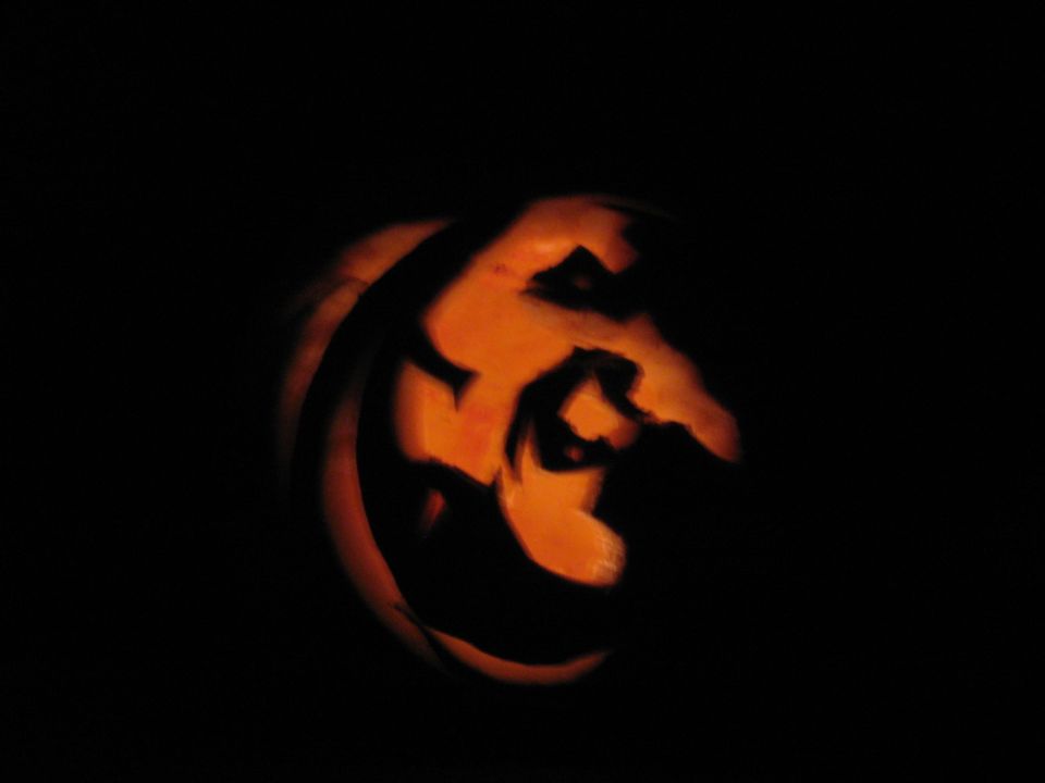 Carved jack-o-lantern with a spooky face illuminated from within
