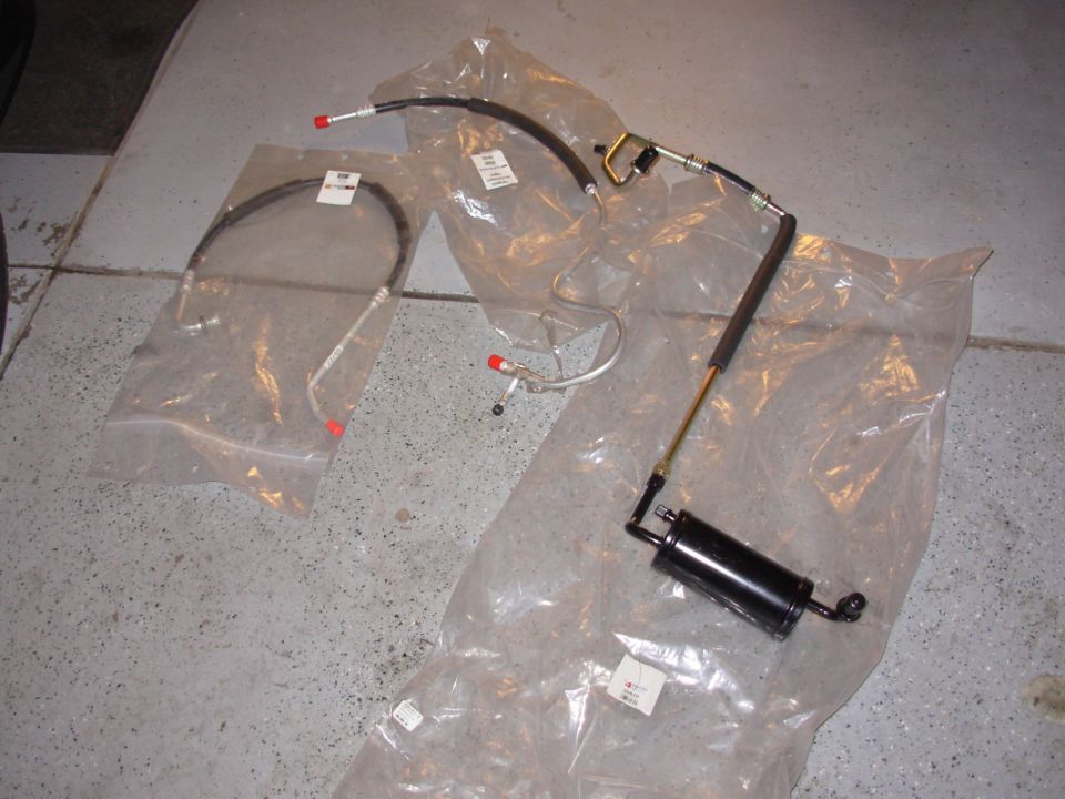 Power steering hose assembly with red caps on fittings