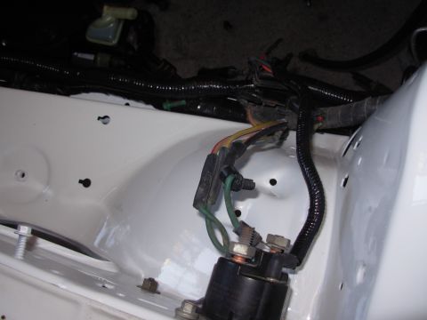 1995 Ford Taurus - Close-up of a starter relay and wiring harness in a white vehicle's engine bay.