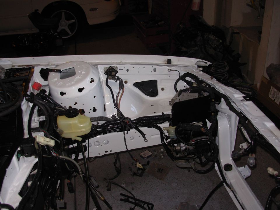 White engine bay with exposed wiring harness and components