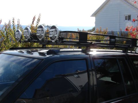 1996 Jeep Grand Cherokee - A black SUV is equipped with a roof rack holding four Hella lights.