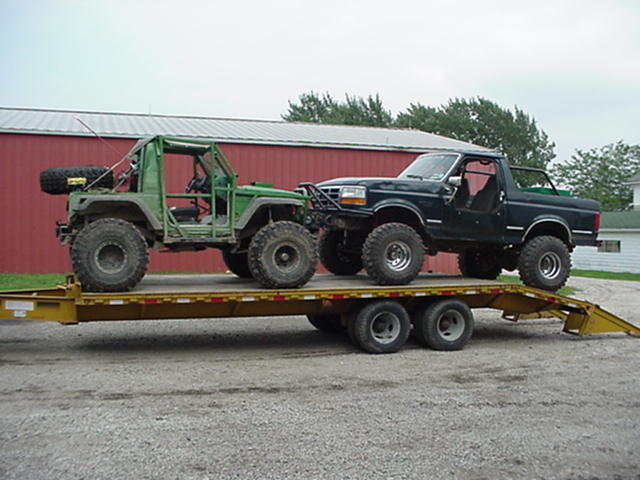 Dark green Bronco and a green off-road buggy on a trailer
