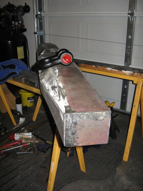 1995 Ford F-150 - Custom metal part being fabricated in a garage setting with tools and equipment visible.