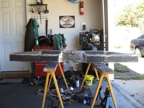 1995 Ford F-150 - A custom-fabricated bumper is supported by sawhorses in a garage setting, surrounded by tools and equipment.