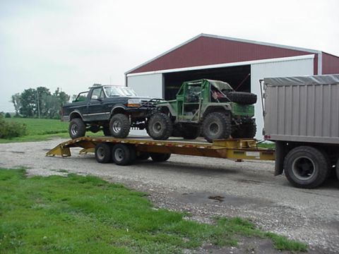 1992 Ford Bronco - A 1992 Ford Bronco and a custom off-road vehicle are transported on a trailer.