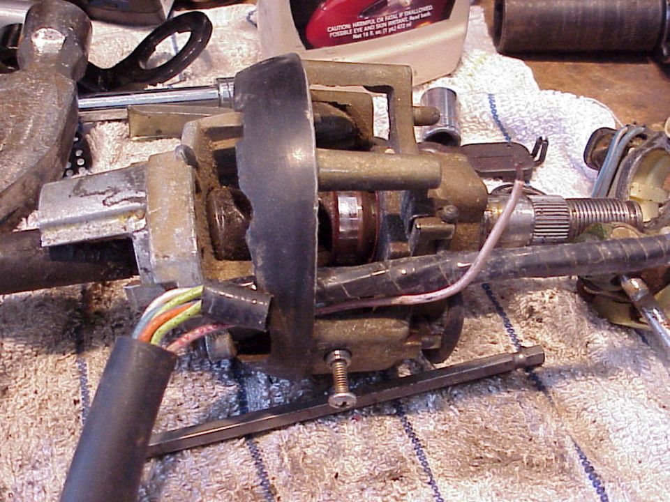 Greasy disassembled steering/gear mechanism clamped in a vise on a workbench